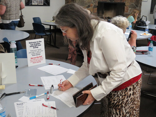 Woman standing at a table and filling out a form